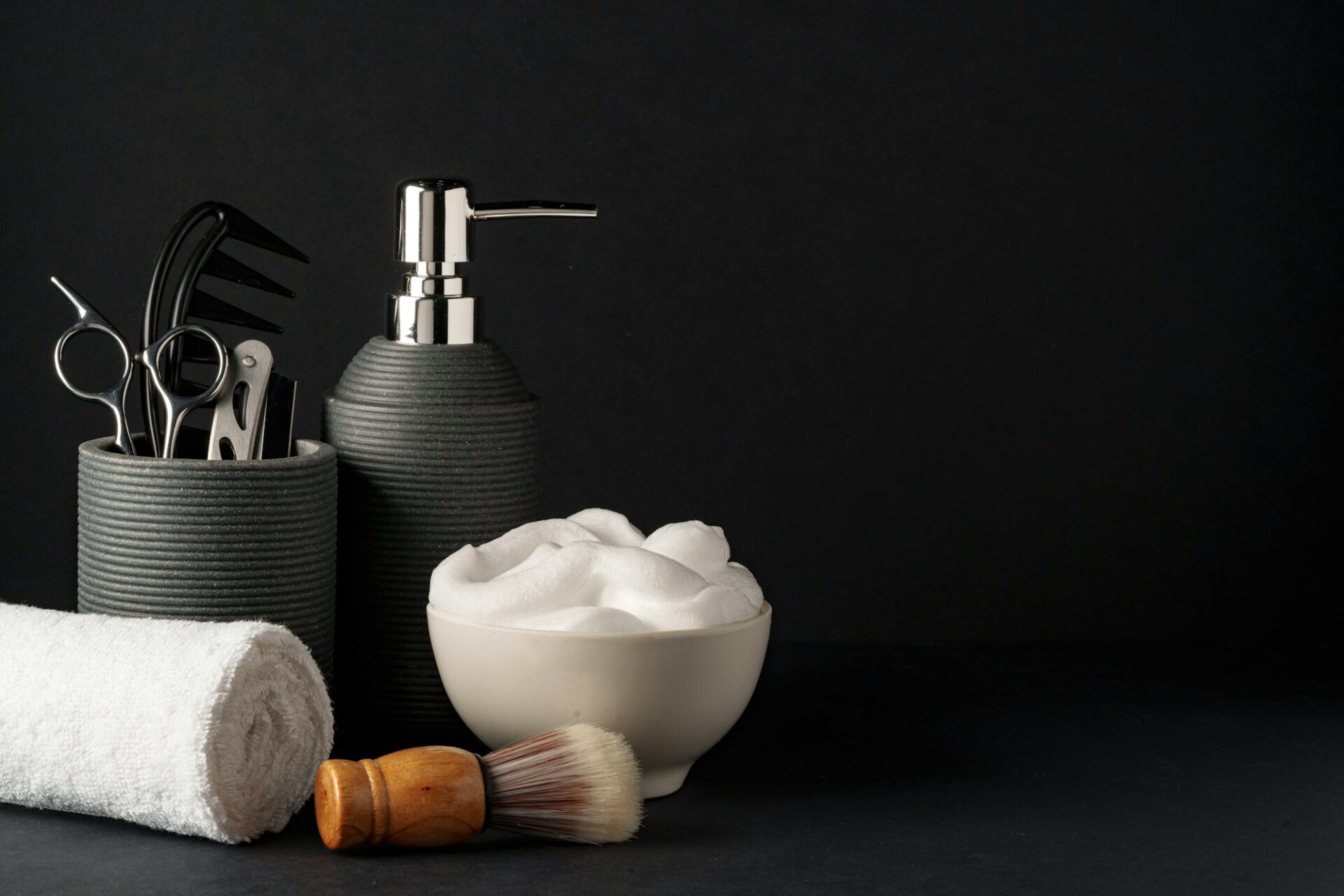 Professional Barber Tools Displayed on Black Background With Towel and Shaving Cream