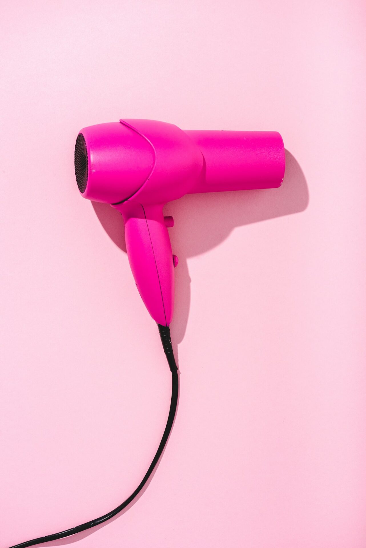 top view of hair dryer on pink with copy space